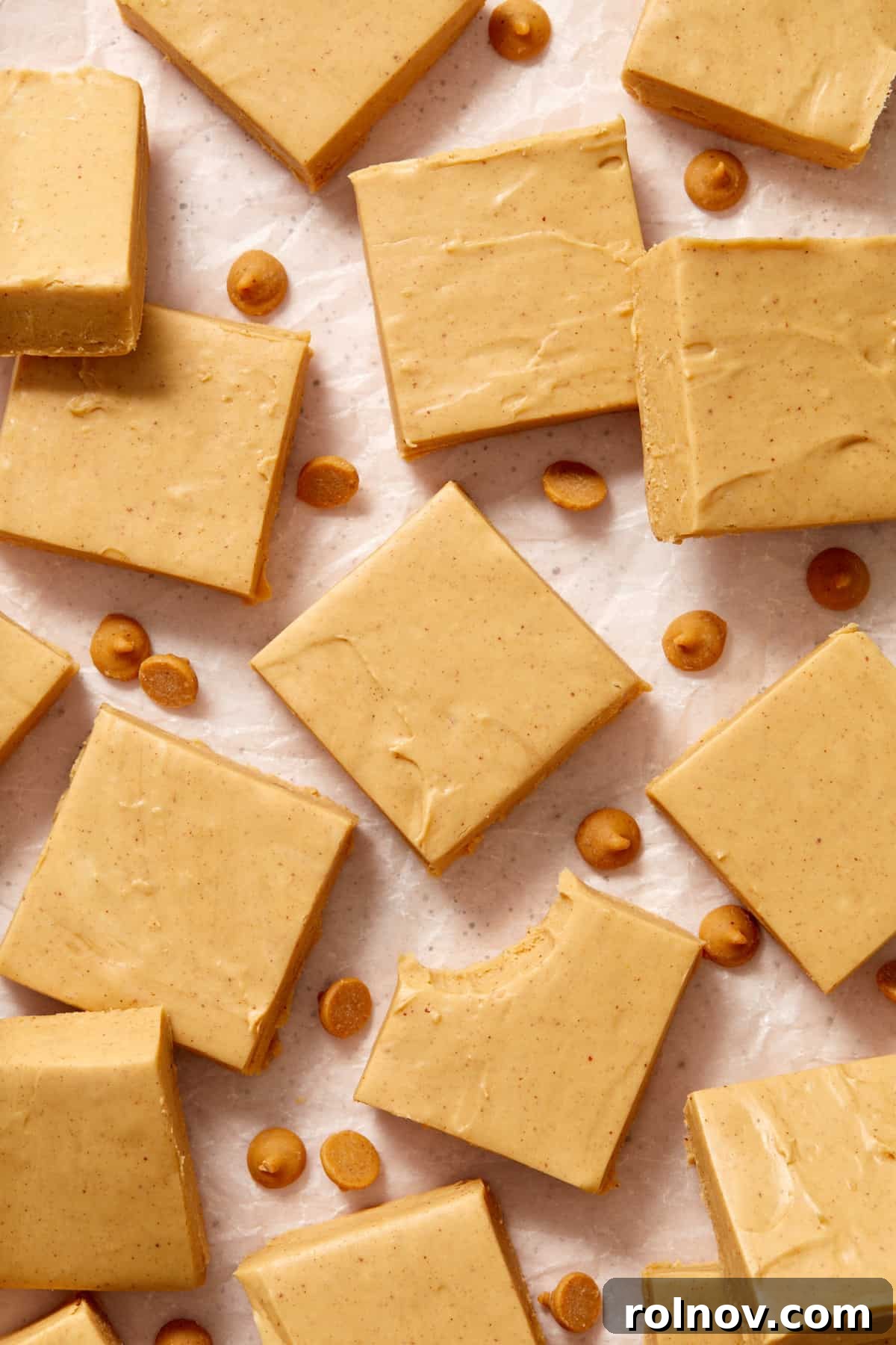 Effortless Peanut Butter Fudge 2 Peanut butter fudge cut in squares arranged on surface with peanut butter chips.