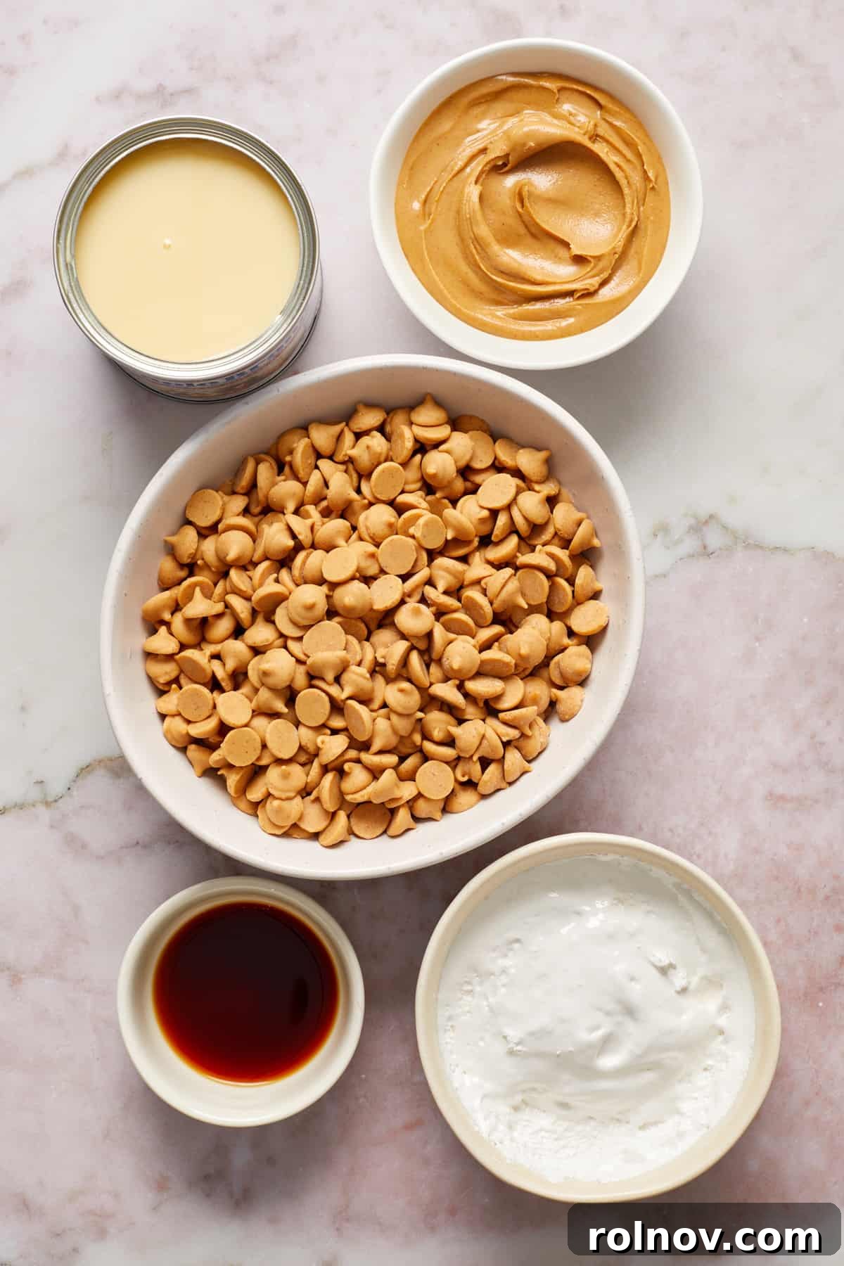Effortless Peanut Butter Fudge 3 Peanut butter chips, condensed milk, marshmallow cream and vanilla in bowls on surface.