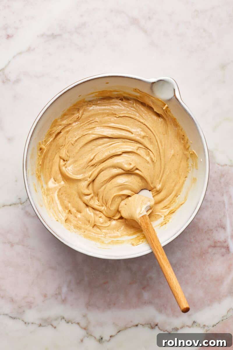 Effortless Peanut Butter Fudge 6 Mixing bowl with microwave peanut butter fudge mixture and spatula.