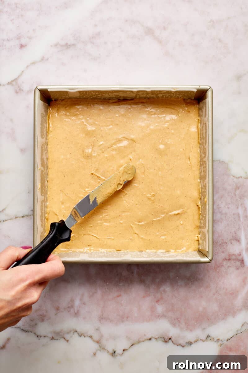Effortless Peanut Butter Fudge 8 Knife smoothing out fudge in pan.