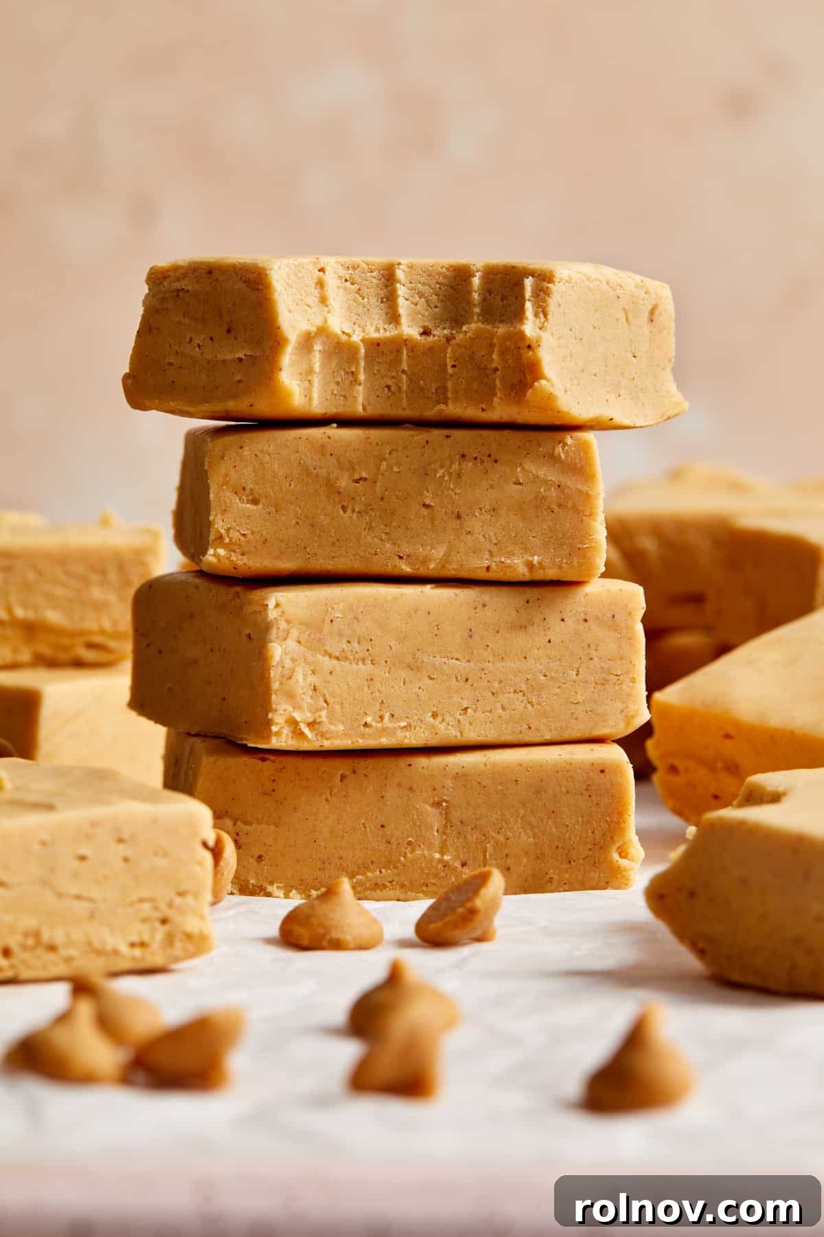 Effortless Peanut Butter Fudge 9 Stack of cut microwave peanut butter fudge pieces with top piece bitten into.