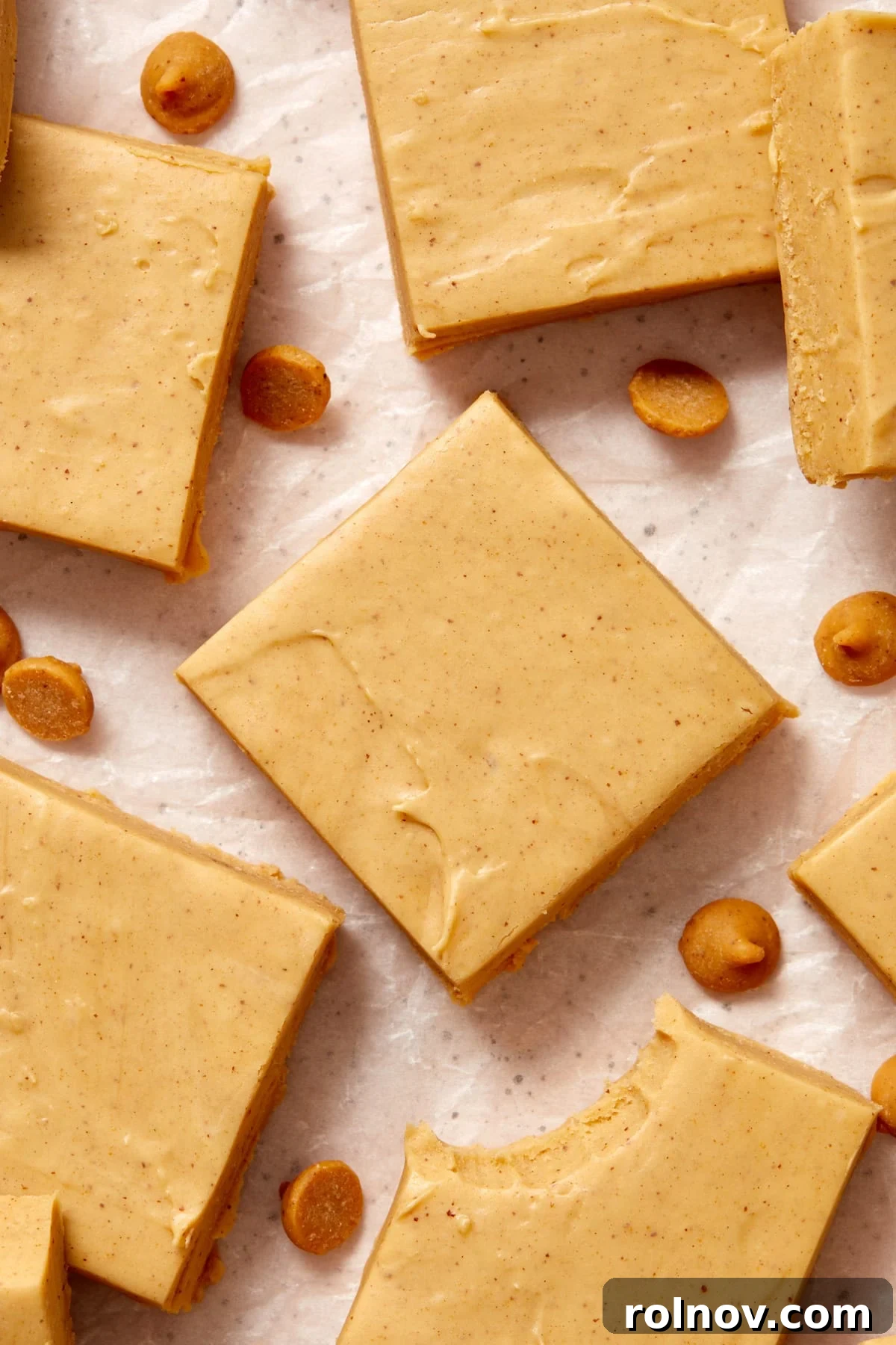 Effortless Peanut Butter Fudge 10 Squares of peanut butter fudge on wax paper with peanut butter chips.