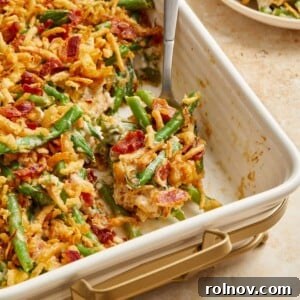 Bacon and green bean casserole in pan with serving spoon.