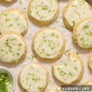 Key lime cookies with lime glaze and zest on surface.