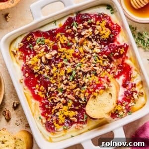 Honey whipped ricotta dip beautifully adorned with cranberry sauce, fresh thyme, toasted pecans, and a delicate honey drizzle.