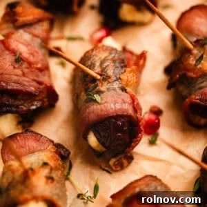 Gourmet bacon wrapped dates, each stuffed with honey whipped feta cheese, presented on parchment paper.