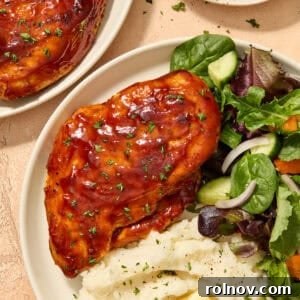 Perfectly cooked Air Fryer BBQ Chicken Breast, glazed with a thick and sticky sauce, served on a plate with fresh side dishes, showcasing a quick and juicy dinner.