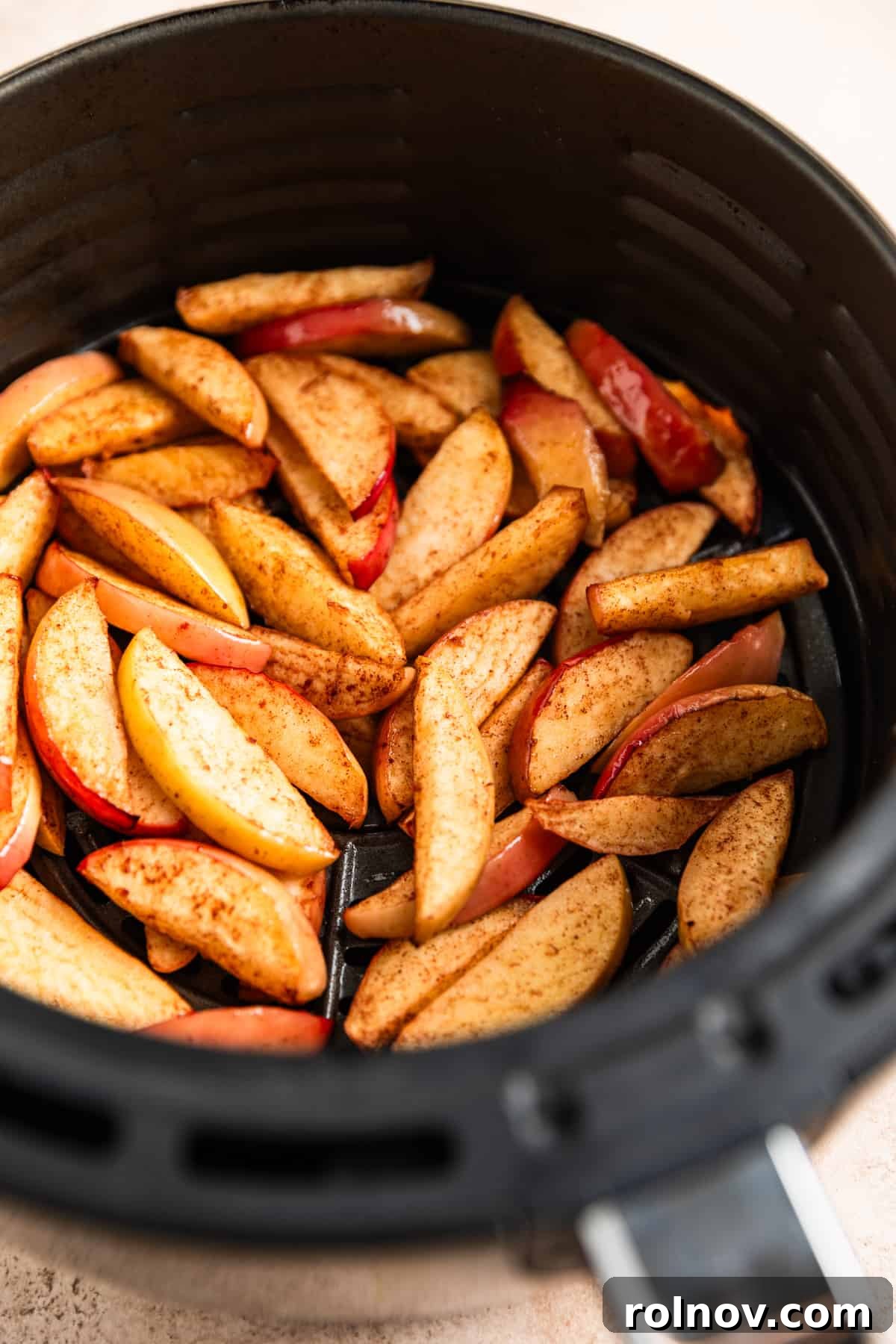Air Fryer Cinnamon Apple Slices 5 Cooked, tender apple slices visible in the air fryer basket after cooking.