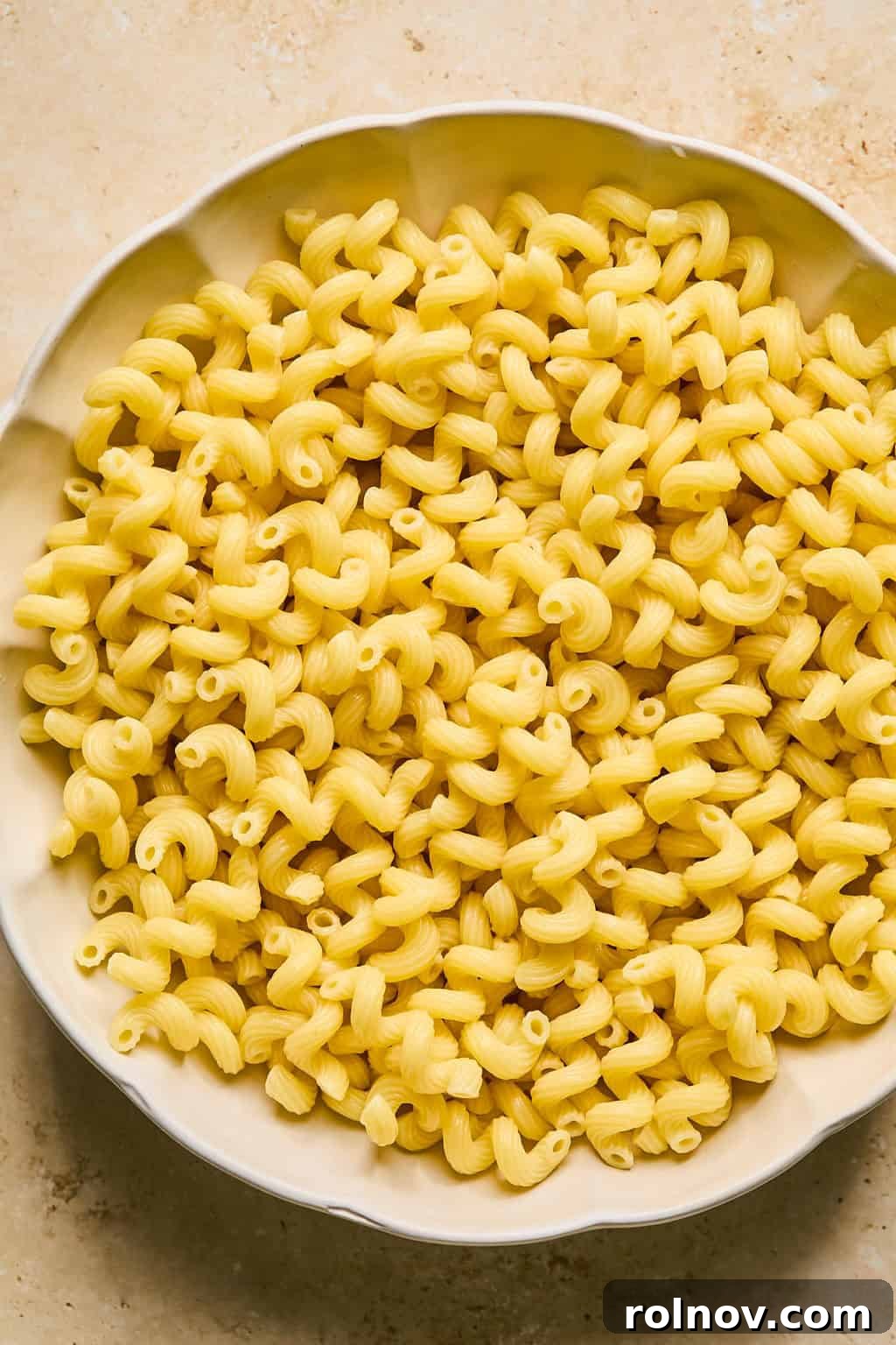Freshly cooked rigatoni pasta in a large mixing bowl.