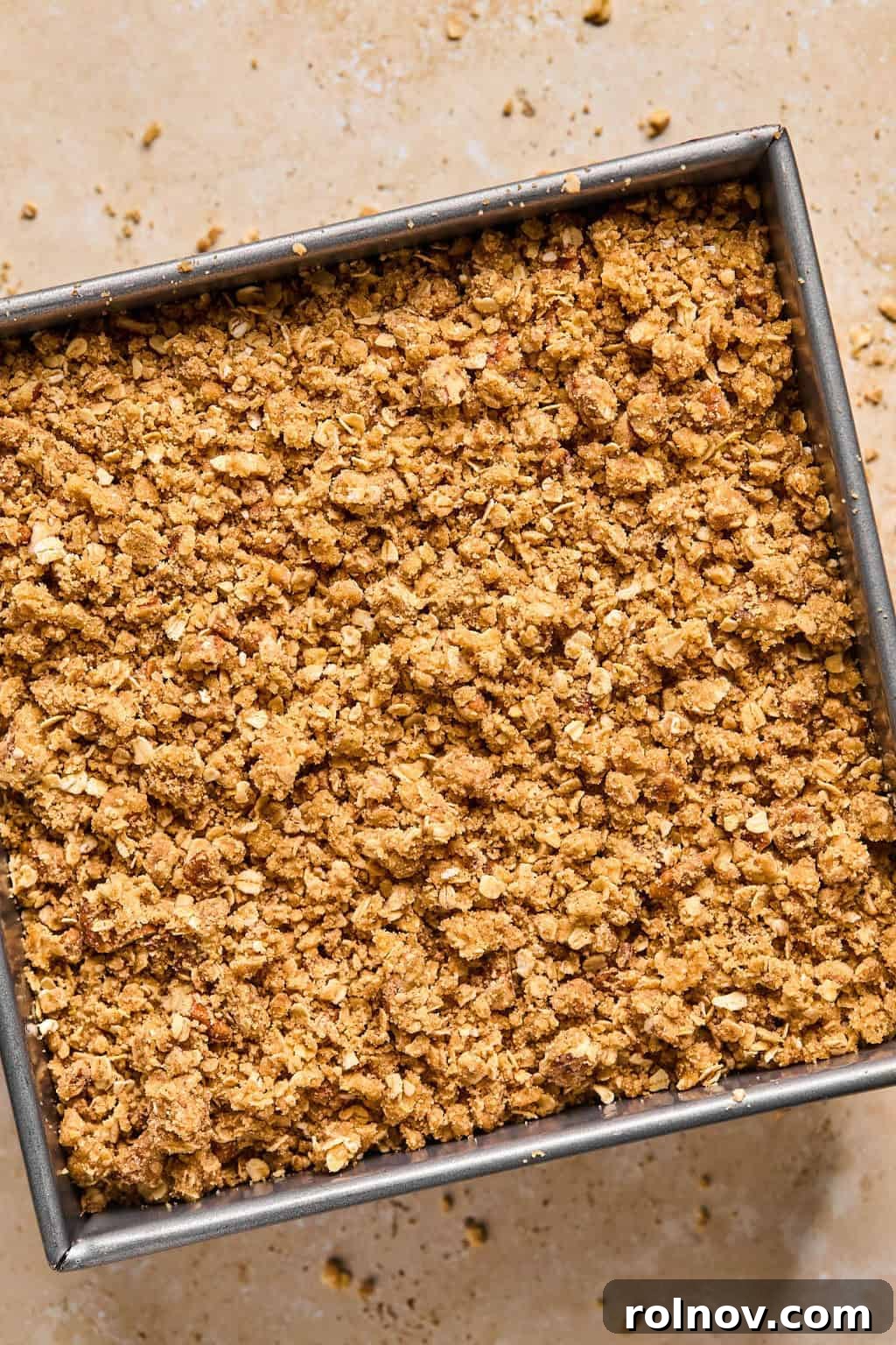 Spiced Pumpkin Crumble 11 Pumpkin crisp in pan with oat topping covering pumpkin layer before baking.