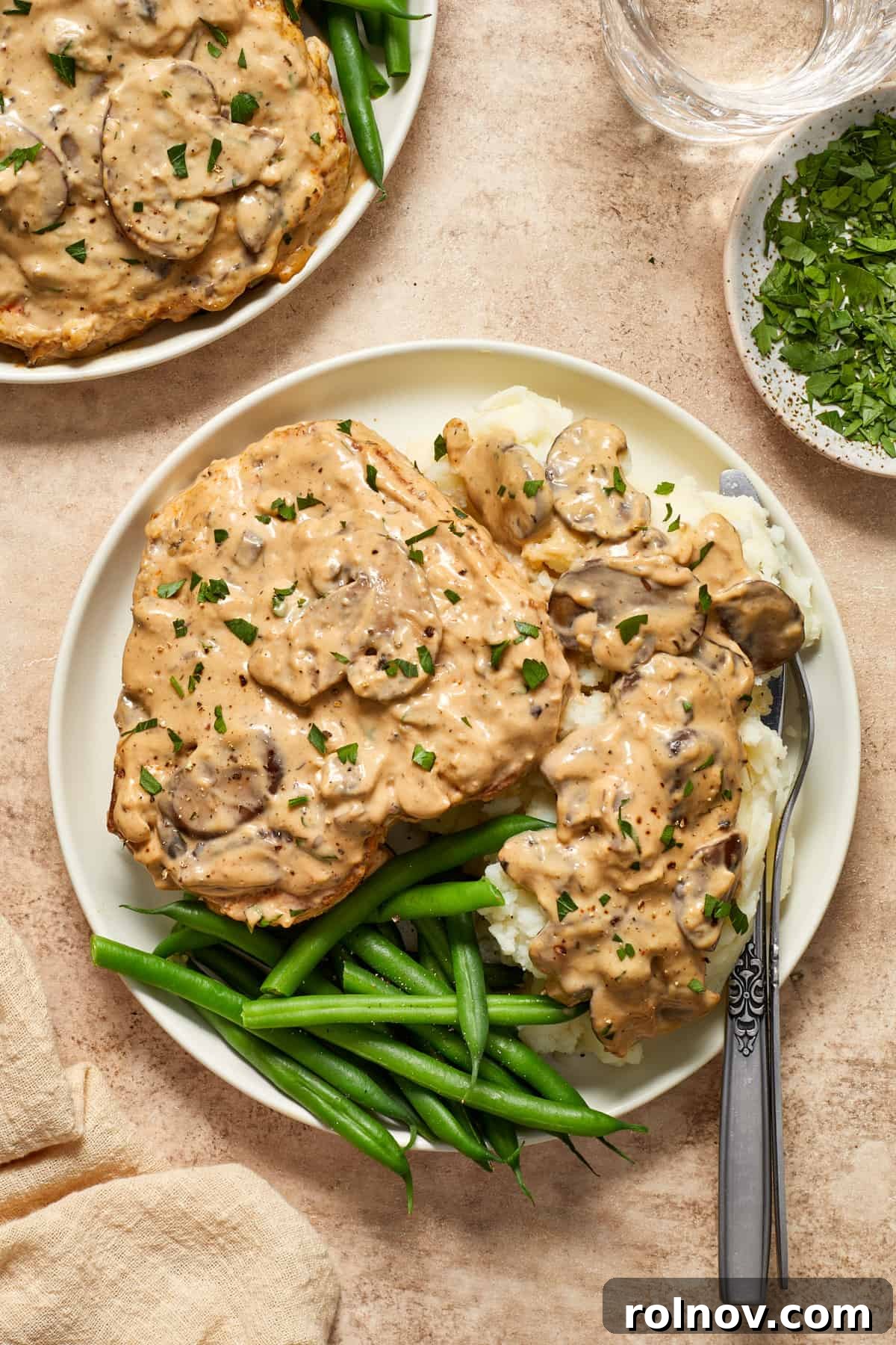 Velvety Mushroom Pork Chops 2 Cream of mushroom pork chop on mashed potatoes with fork