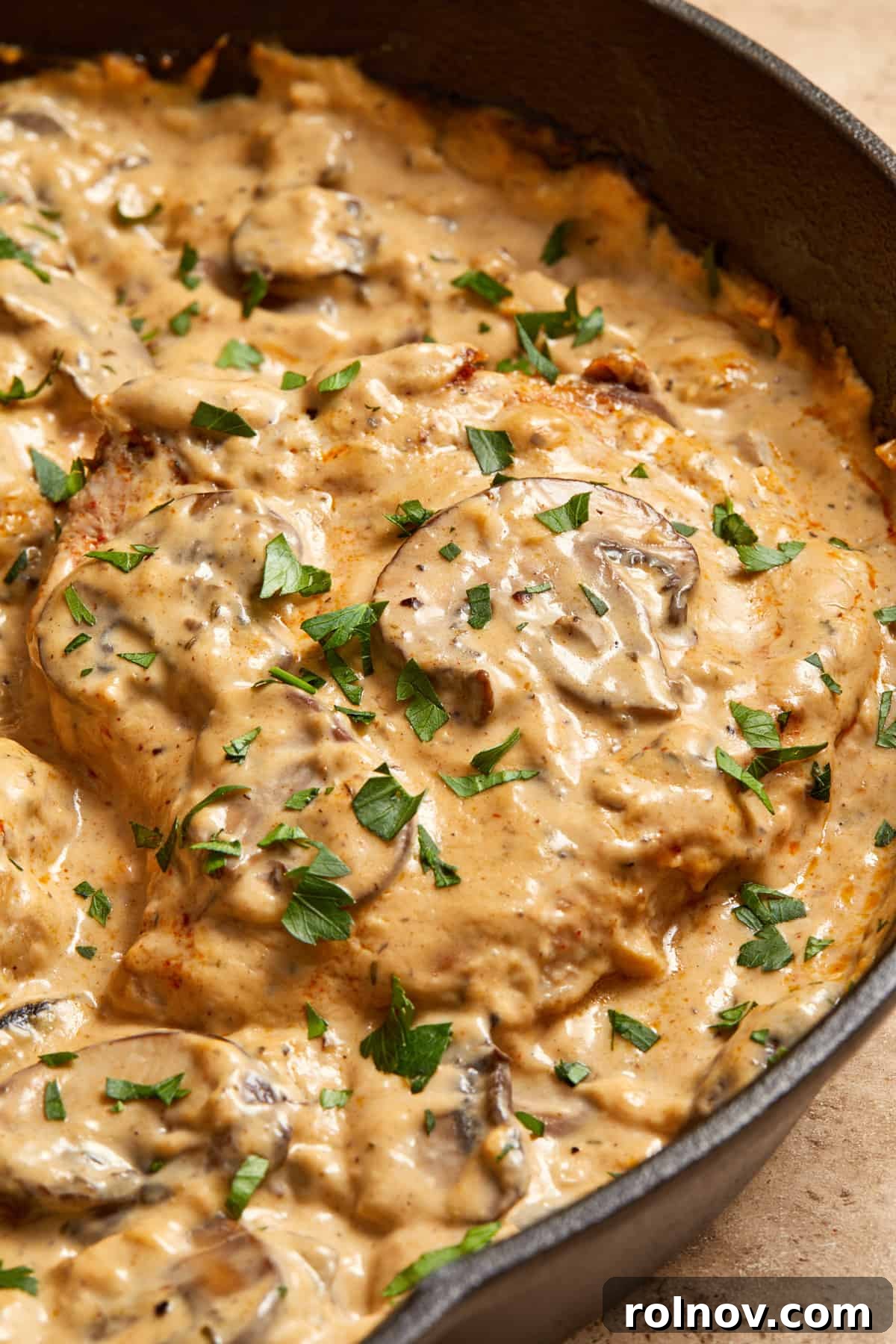 Velvety Mushroom Pork Chops 13 Skillet with cream of mushroom pork chops with parsley on top.
