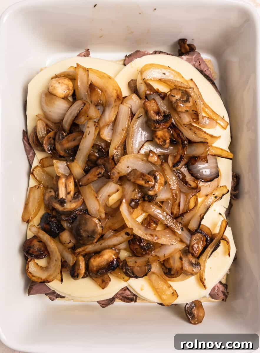 Ultimate French Dip Sliders 8 Caramelized onions and mushrooms spread generously on top of the cheese and beef layers.
