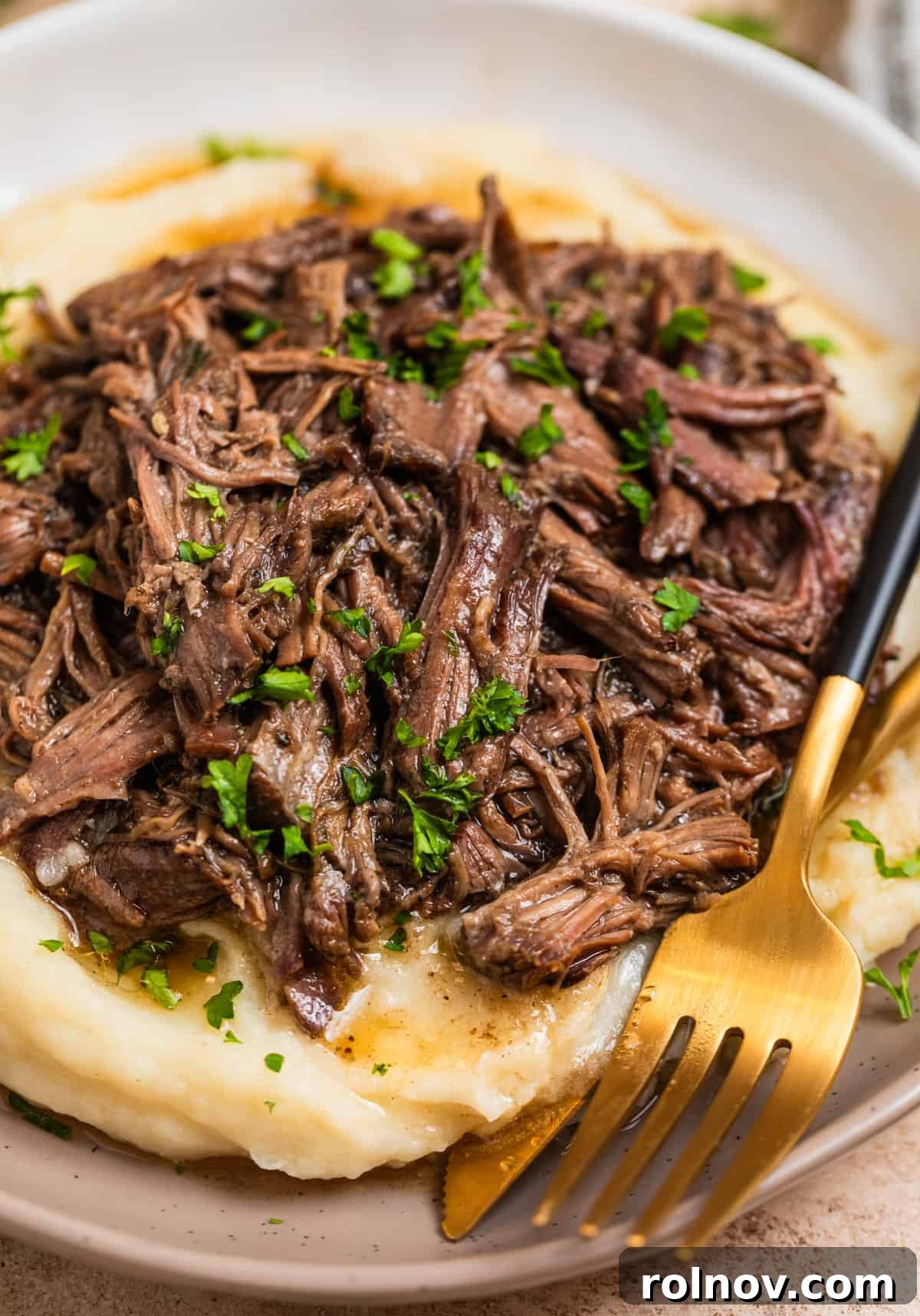 Dish with mashed potatoes topped with crock pot shredded beef.