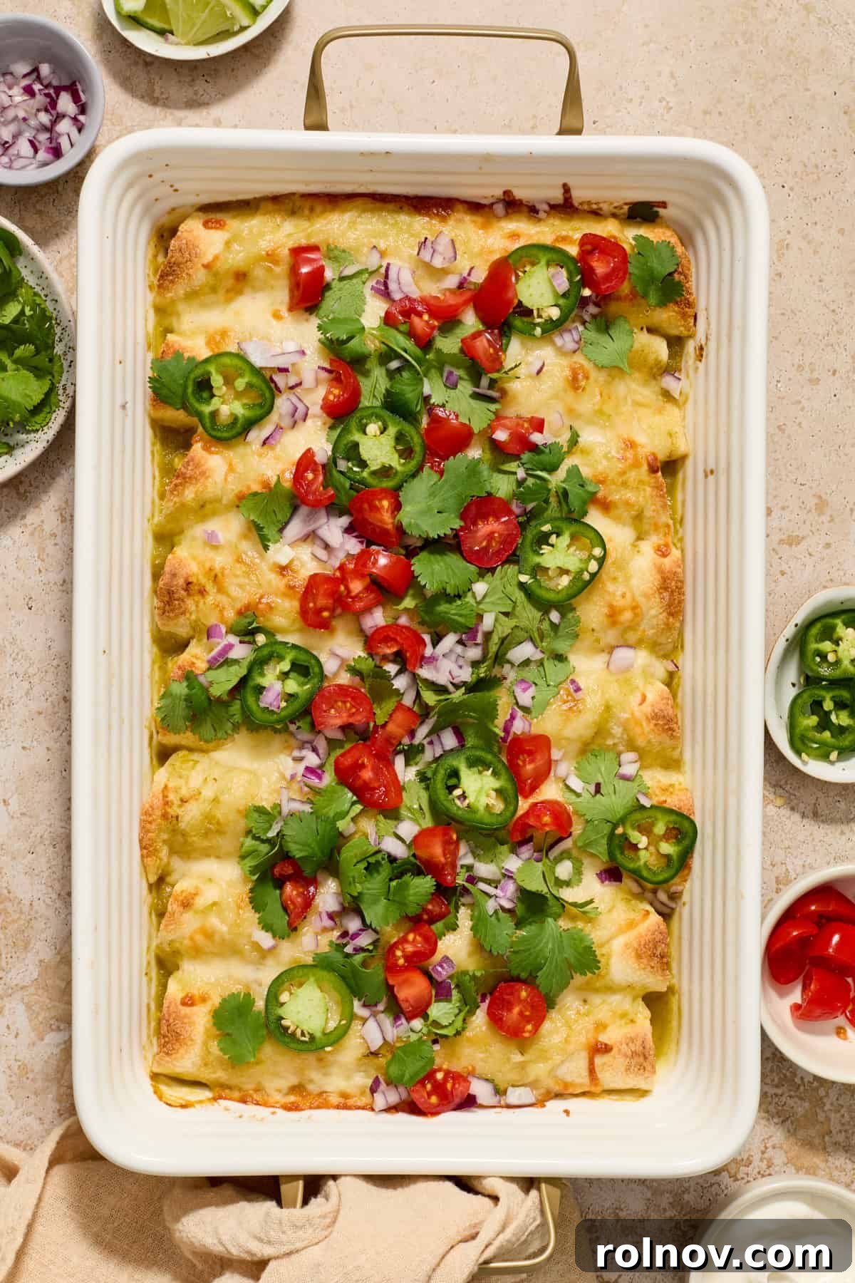 Zesty Verde Chicken Enchiladas 2 Pan with chicken enchiladas in green sauce with melted cheese and chopped cilantro on top.
