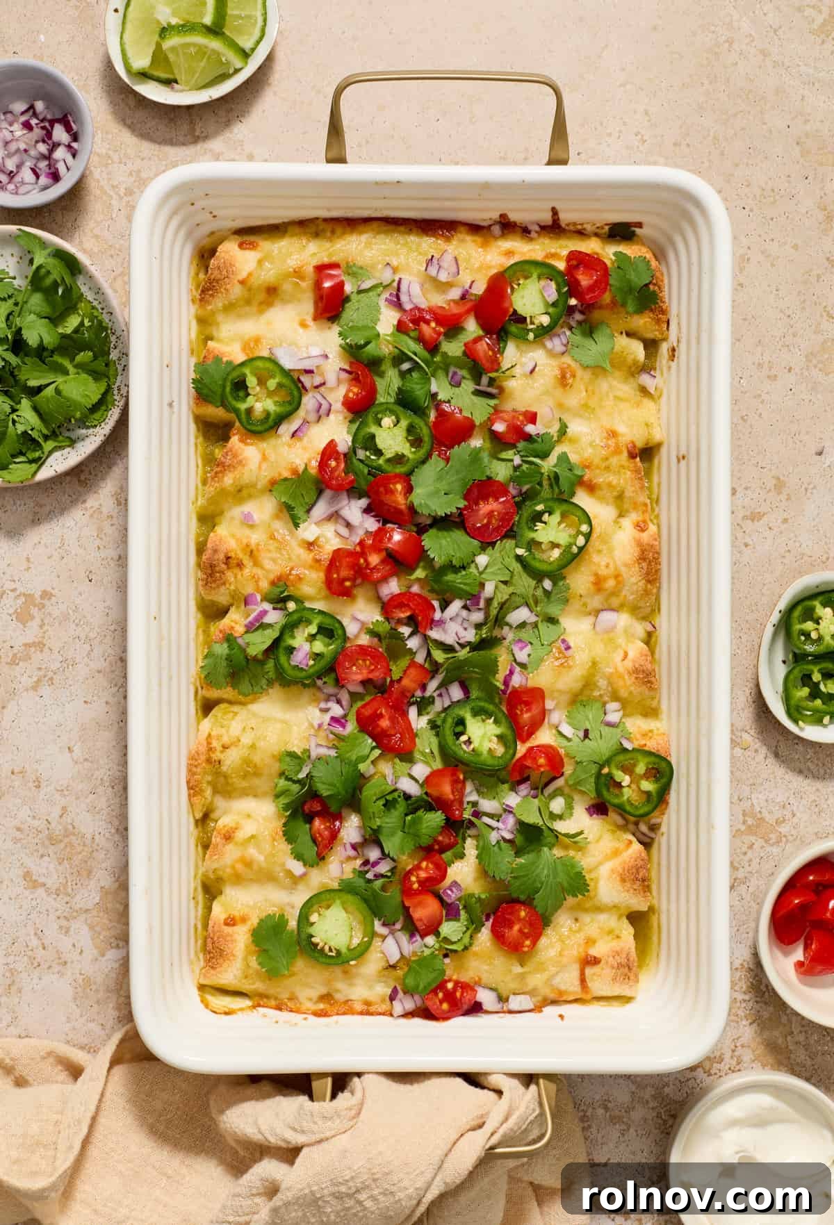 Zesty Verde Chicken Enchiladas 11 Pan of enchiladas topped with tomatoes, onions, cilantro, and jalapeños.
