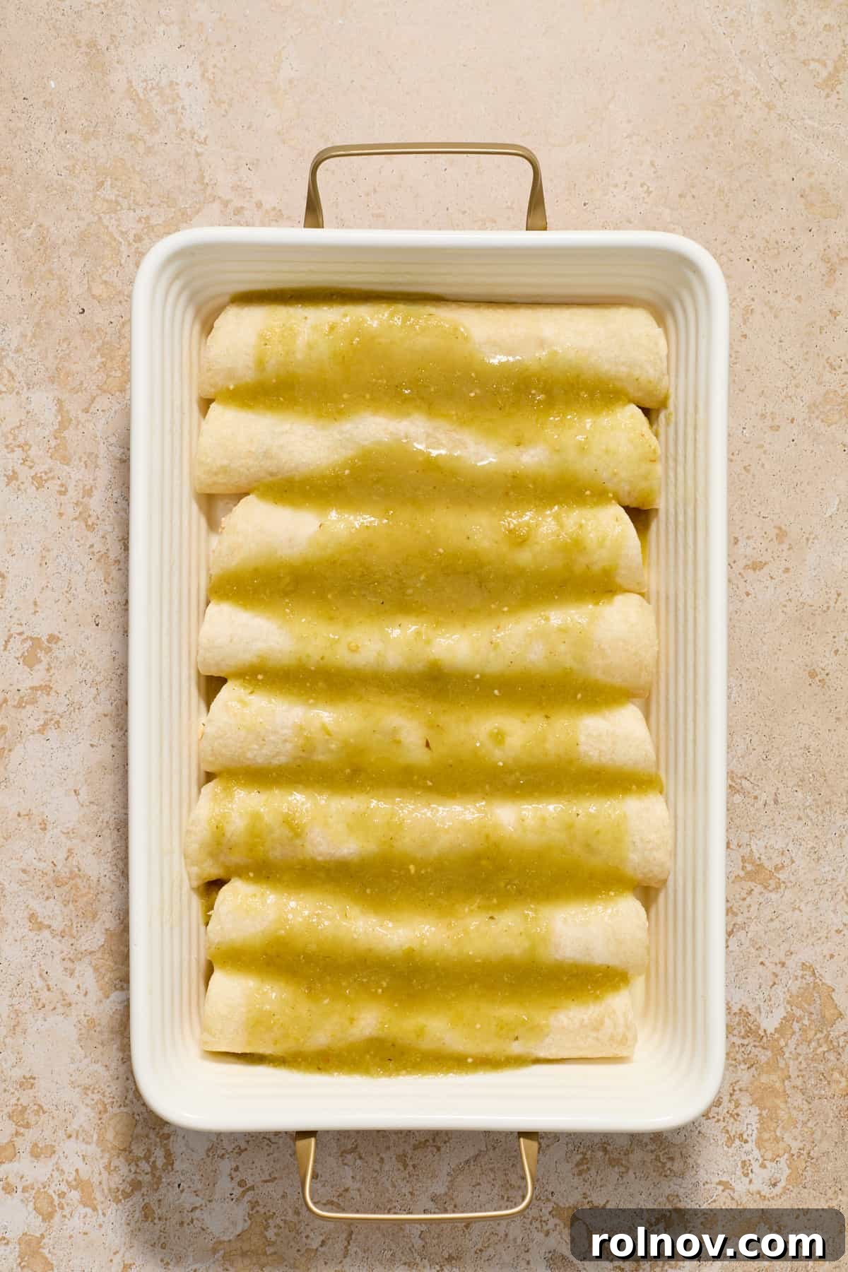 Zesty Verde Chicken Enchiladas 8 Chicken enchiladas in pan with green enchiladas sauce on top.