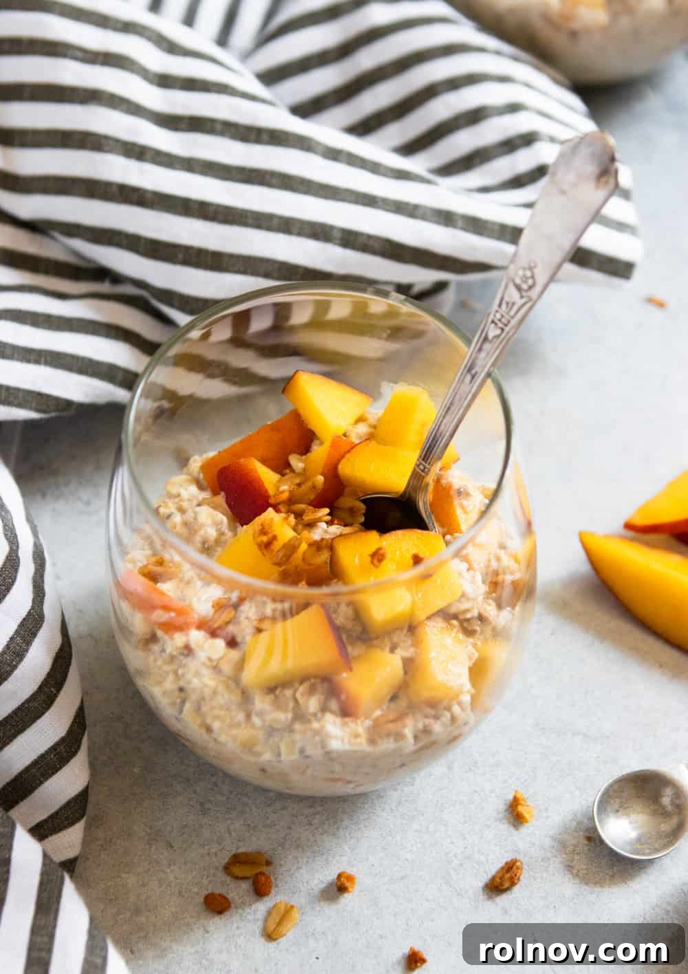 Peach Pie Bliss Overnight Oats 2 Fresh Peach Overnight Oats served in a glass jar with a spoon, garnished with additional peach slices and a sprinkle of cinnamon.