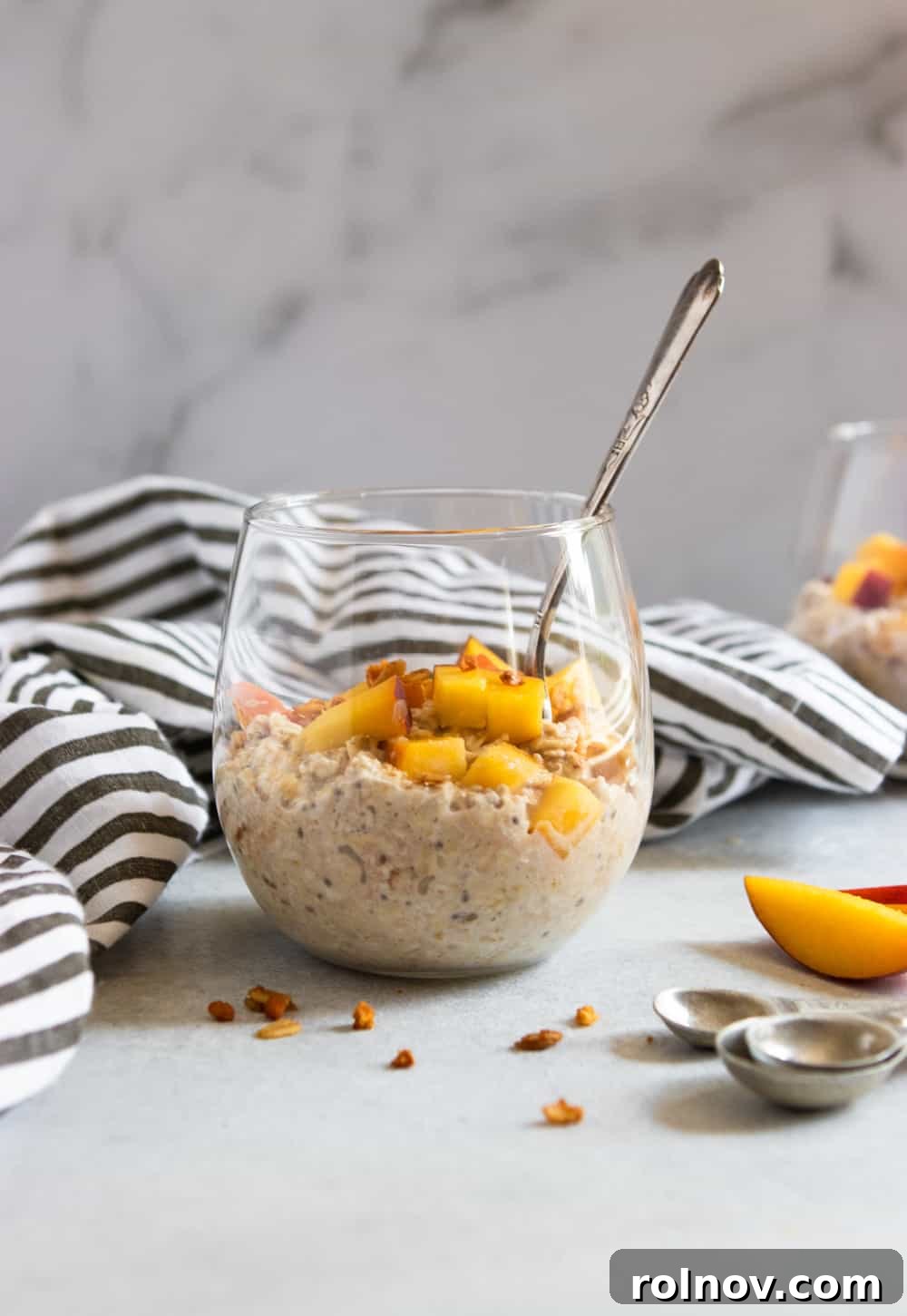 Peach Pie Bliss Overnight Oats 3 Creamy Peach Overnight Oats in a glass jar, topped with crunchy granola and fresh fruit slices.