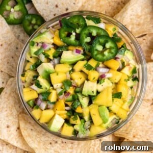 Overhead view of mango avocado salsa in bowl with chips.