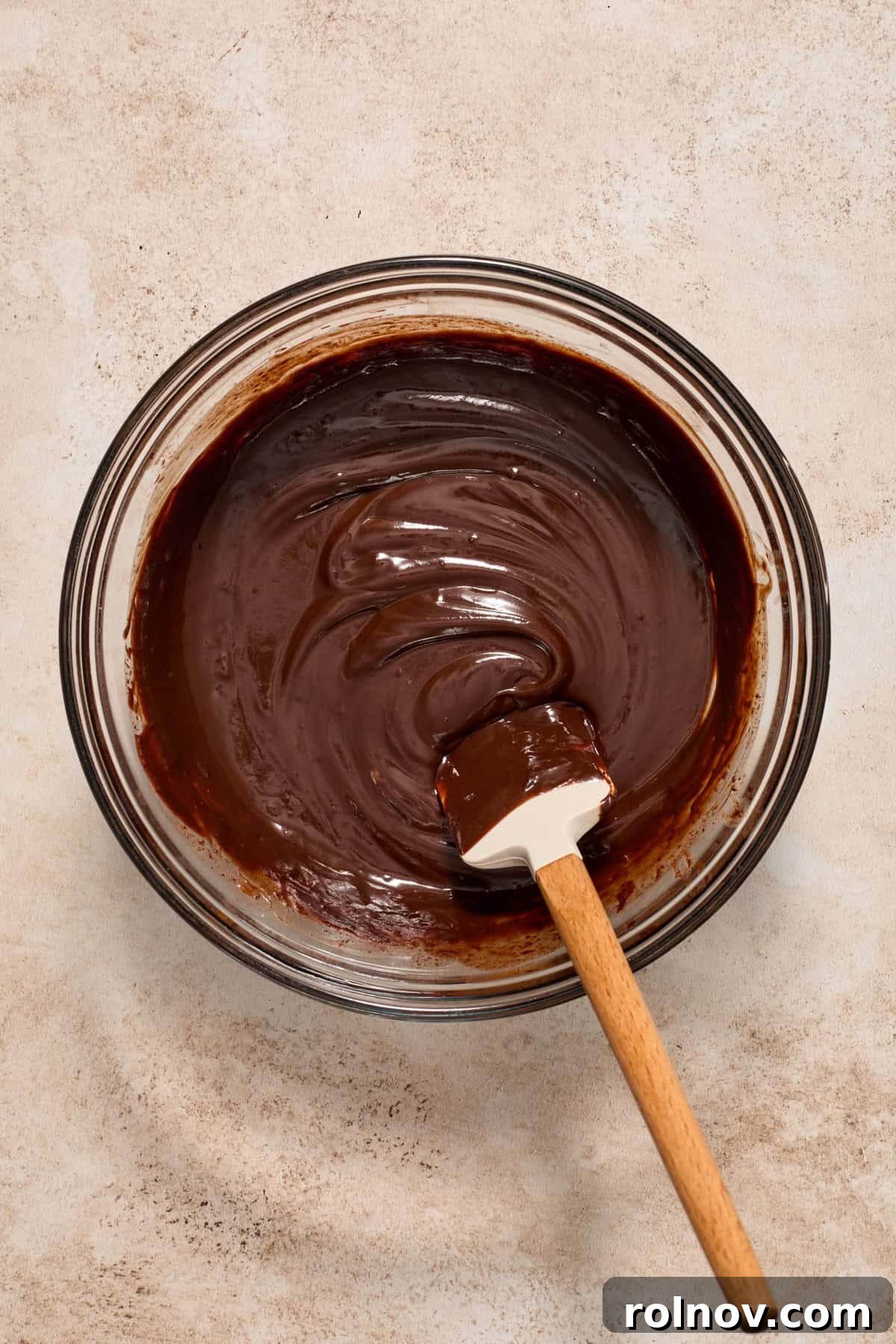 Velvety No Bake Chocolate Pie 9 Melted dark chocolate in glass mixing bowl with spatula.