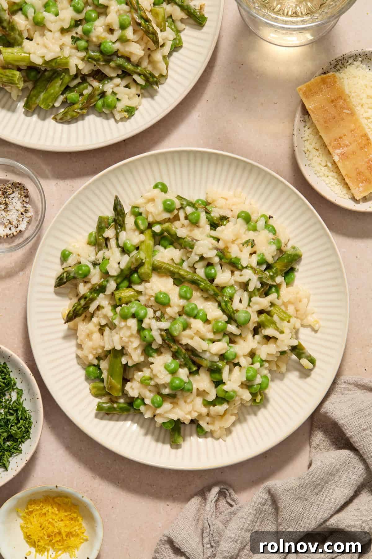 Springtime Pea and Asparagus Risotto 13 Plate with risotto with peas and asparagus with dishes surrounding.