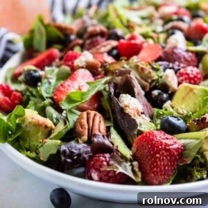 Berries and pecans over green salad.