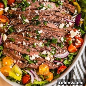 Grilled flank steak salad in dish topped with freshly chopped cilantro and cheese.