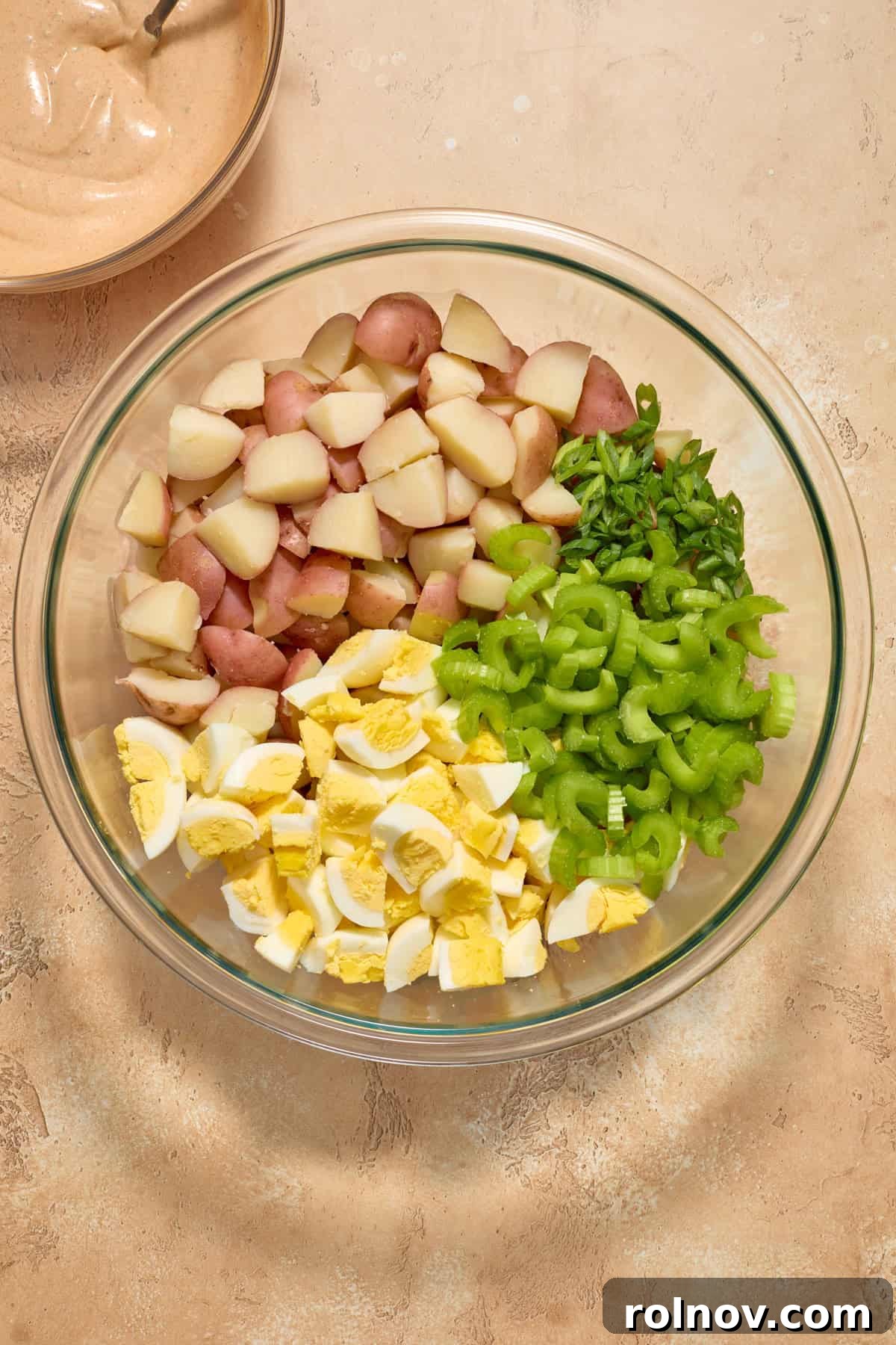 Bayou Potato Salad 8 Boiled potatoes, chopped eggs, celery, and green onion in a large glass bowl before being mixed with dressing.