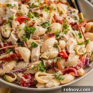 Dish with chicken bacon pasta salad and serving spoon.