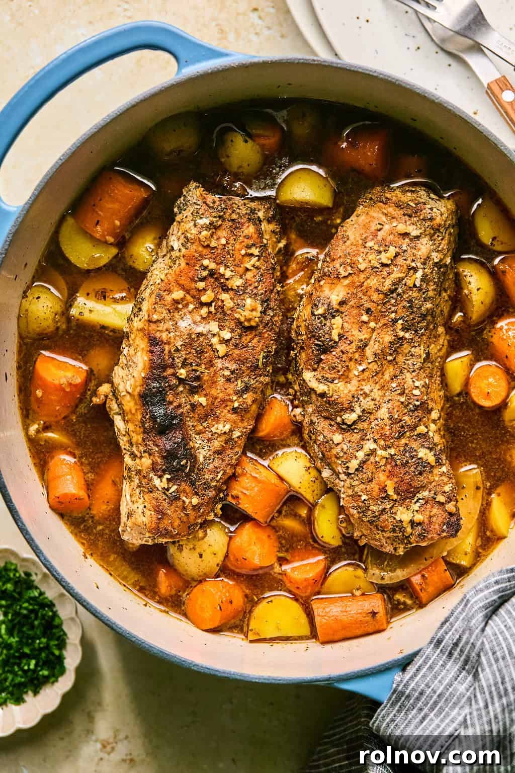 Succulent Dutch Oven Pork Tenderloin 2 Honey garlic glazed pork tenderloin in dutch oven pot with carrots and potatoes in pot.