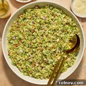 Elevate Your Gnocchi Side Dishes That Shine 9 Brussels sprout salad in bowl with serving utensils, topped with shredded parmesan cheese.