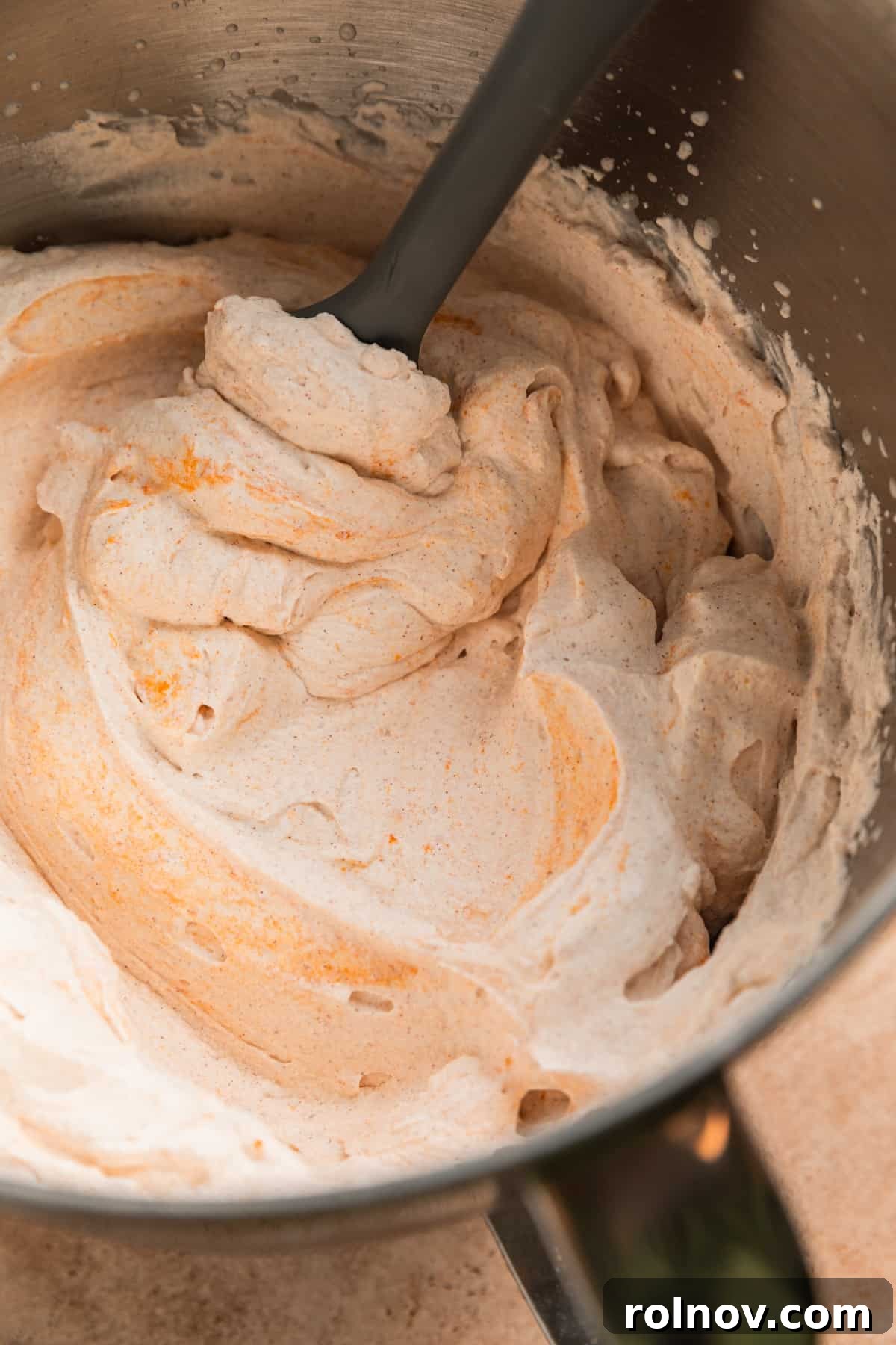 Autumn's Pumpkin Cloud 6 Pumpkin spiced whipped cream in bowl with spatula.
