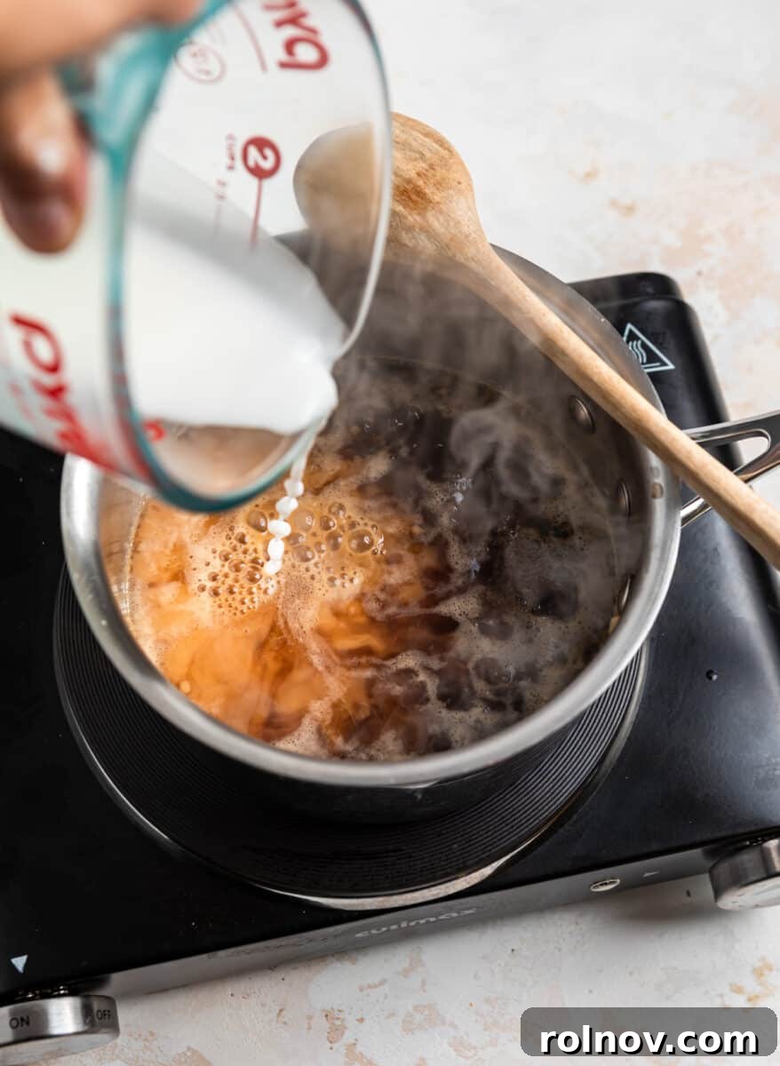 Sticky Teriyaki Pork Stir Fry 5 Corn starch slurry being carefully poured into the simmering teriyaki sauce.