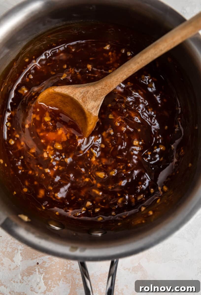 Sticky Teriyaki Pork Stir Fry 6 Thickened teriyaki sauce in a saucepan, ready for use, with a wooden spoon inside.