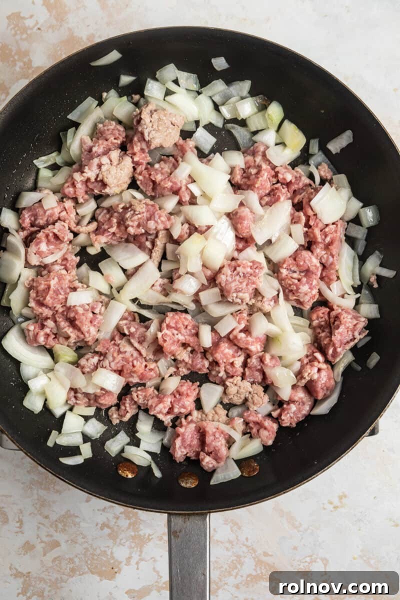 Sticky Teriyaki Pork Stir Fry 7 Ground pork and diced onions cooking in a skillet.