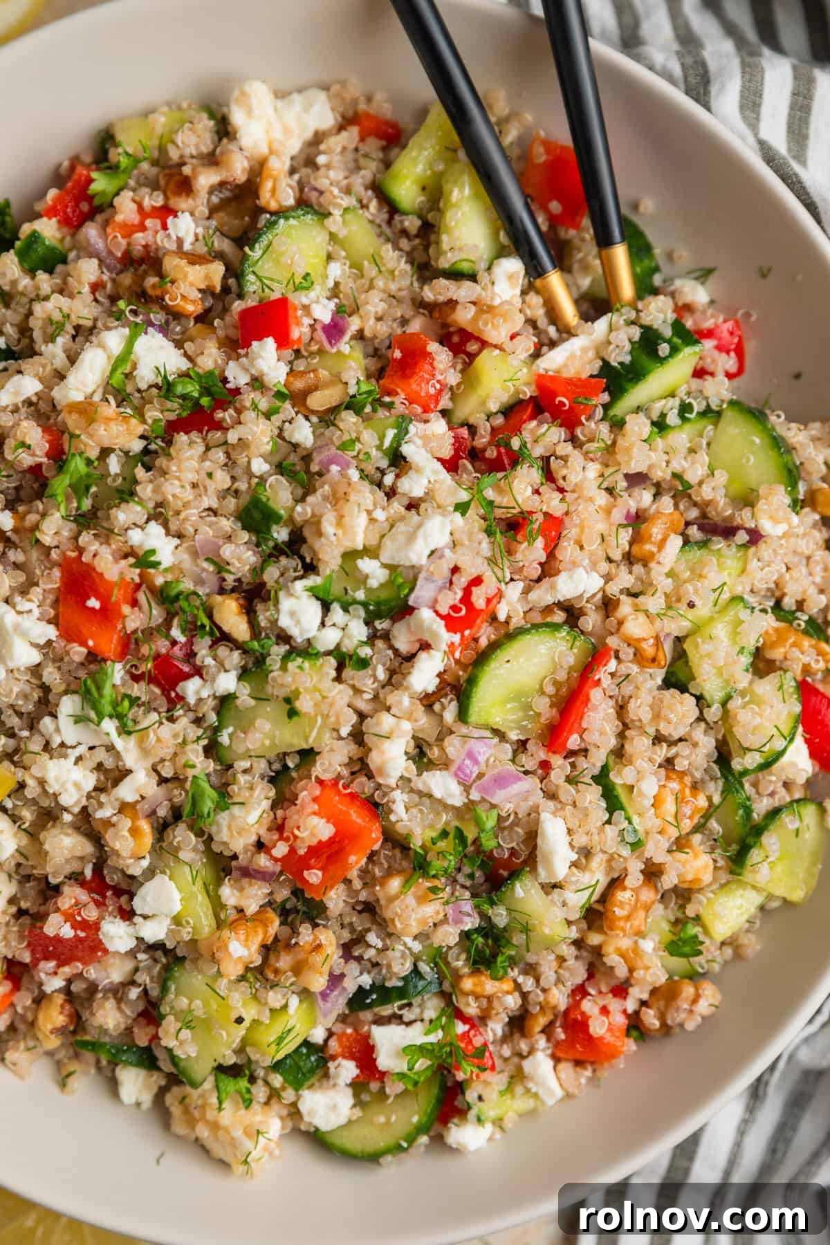 Zesty Cucumber Feta Quinoa Bowl 2 A large, inviting bowl filled with vibrant Cucumber Quinoa Feta Salad, featuring fluffy quinoa, diced cucumbers, bright red pepper, crumbled feta cheese, and fresh green dill, ready to be served.