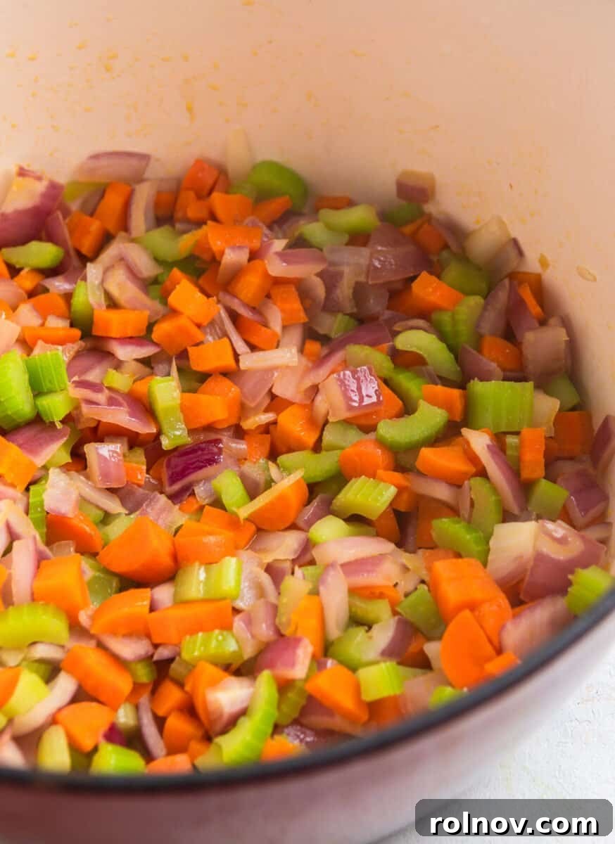 Cooked carrots, celery and onion in red dutch oven.
