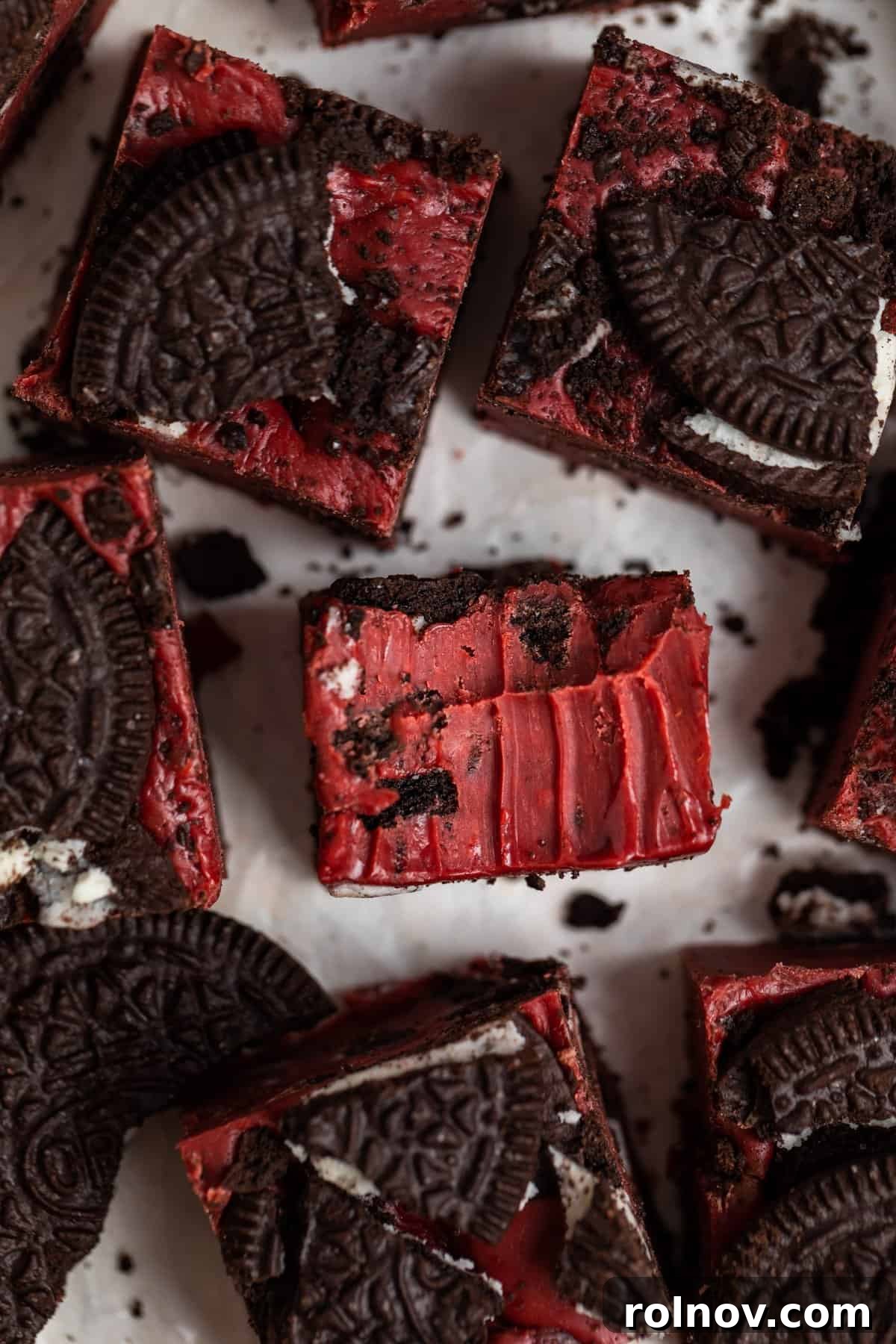 Bite taken out of Oreo red velvet fudge piece surrounded by other pieces of fudge.