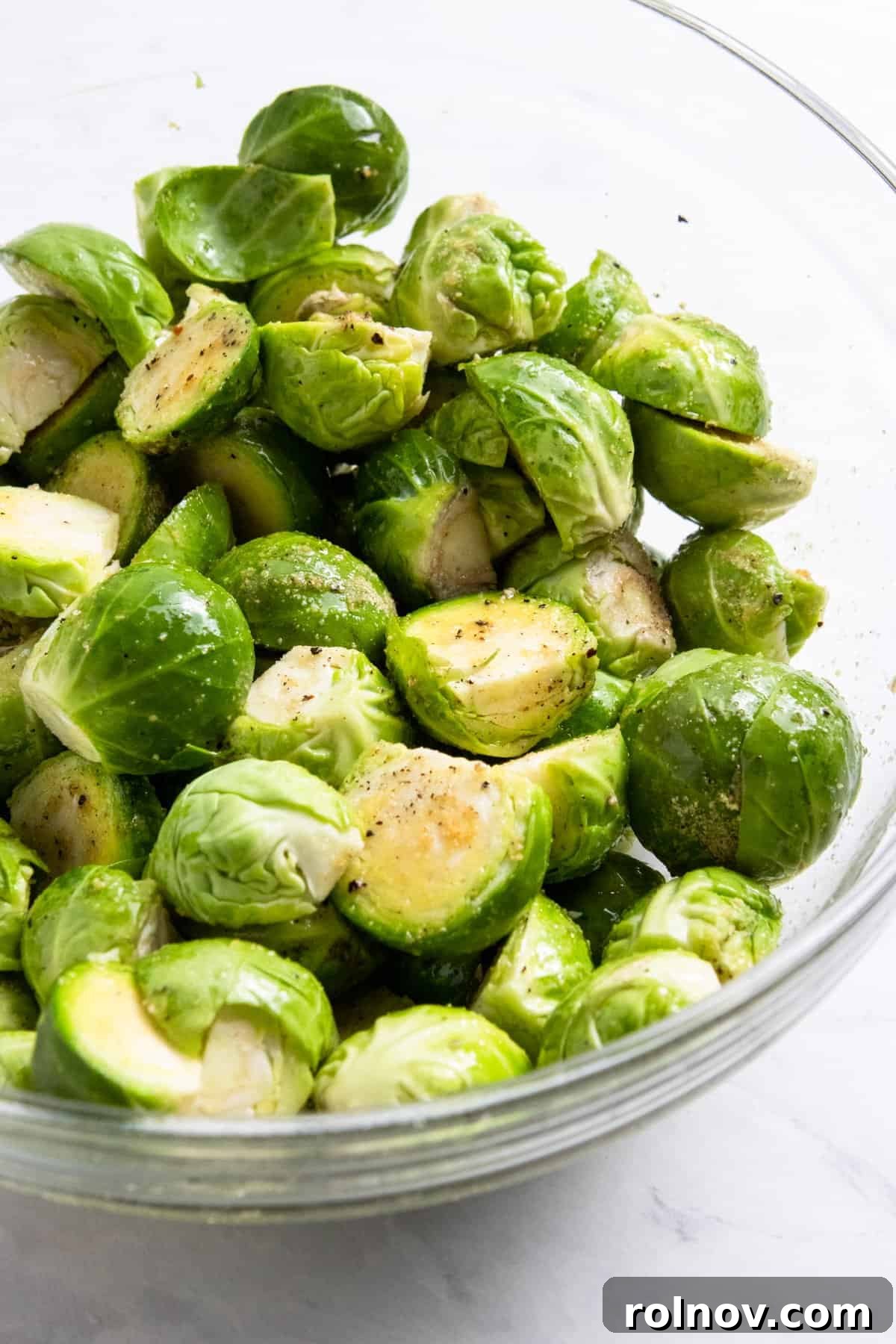 Perfect Pairings for Brussels Sprouts 3 Glass bowl with brussels sprouts tossed in olive oil and seasonings, ready for roasting.