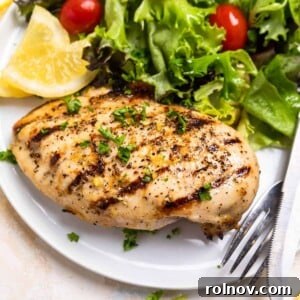 Perfect Pairings for Brussels Sprouts 7 Grilled lemon pepper chicken on white plate with lemon slices and salad.