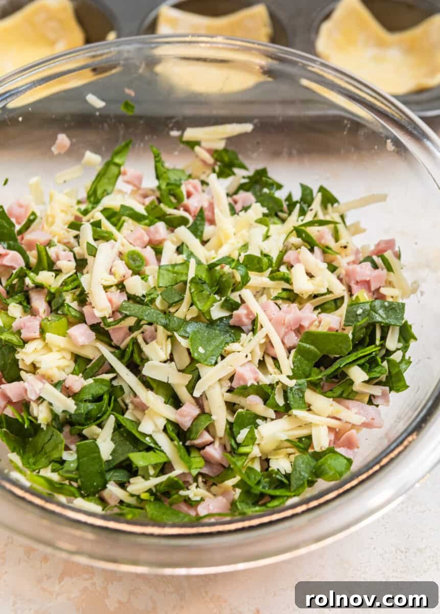 Buttery Flaky Quiche 5 Ham, cheese and spinach mixture in glass mixing bowl.