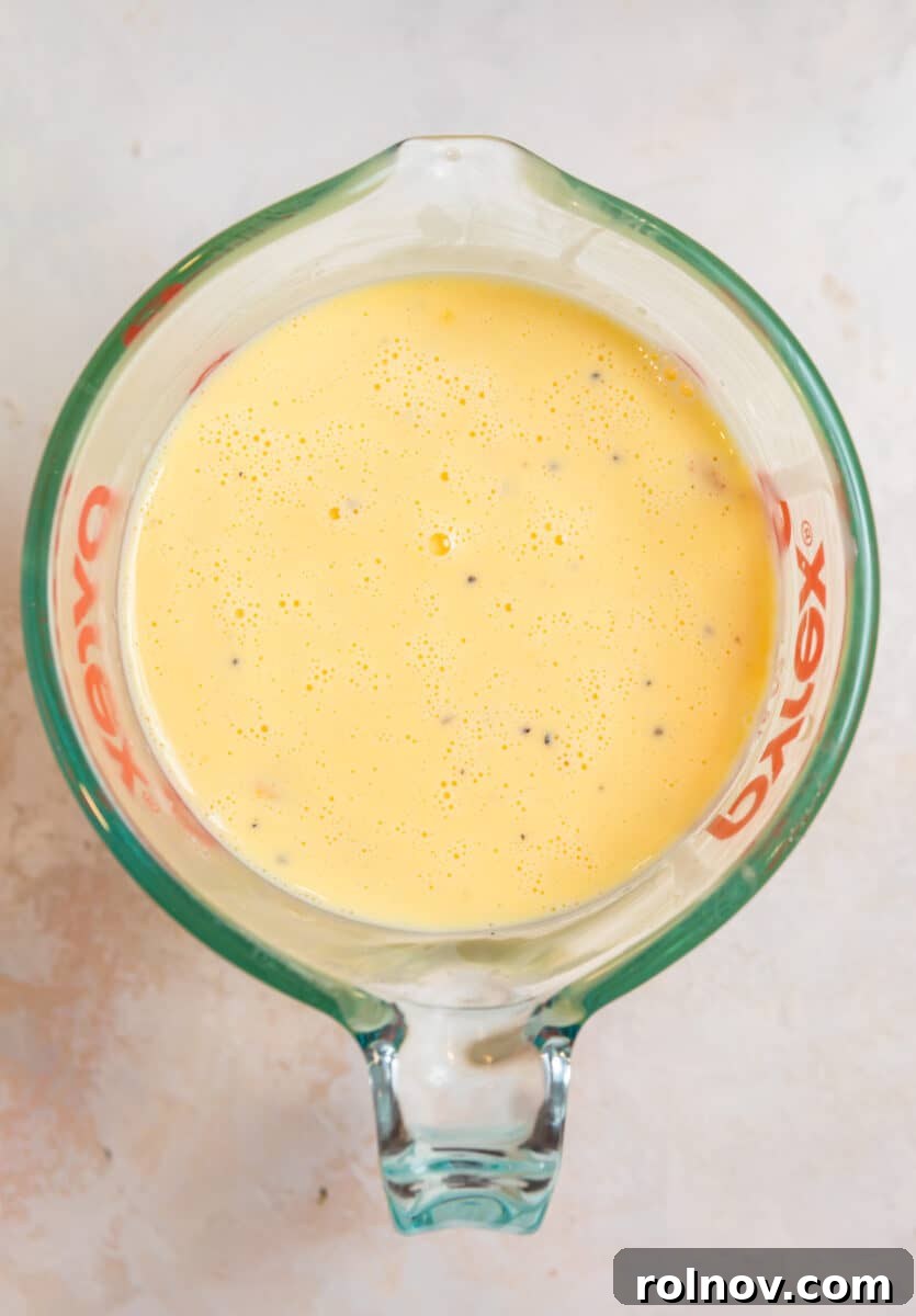Buttery Flaky Quiche 6 Egg and cream mixture in measuring cup with spout.
