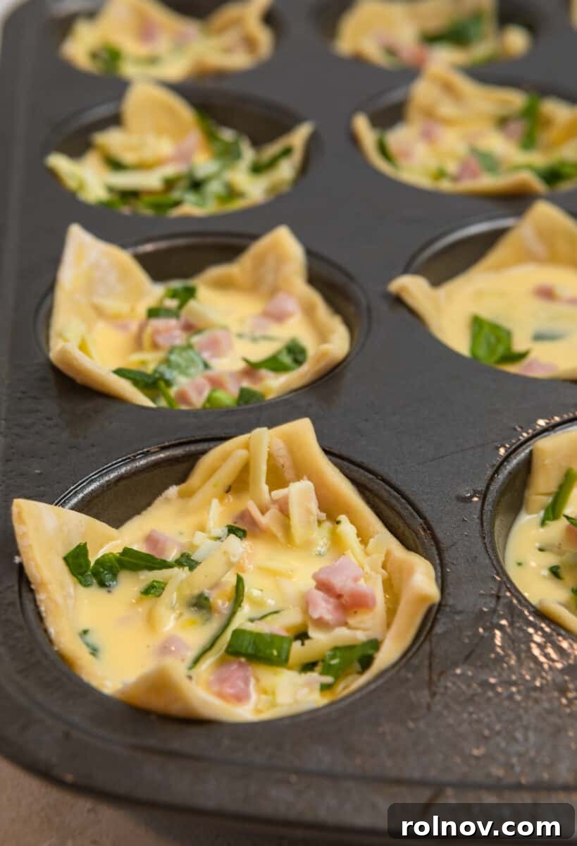 Buttery Flaky Quiche 10 Egg mixture poured into puff pastry muffin cups in muffin tin.