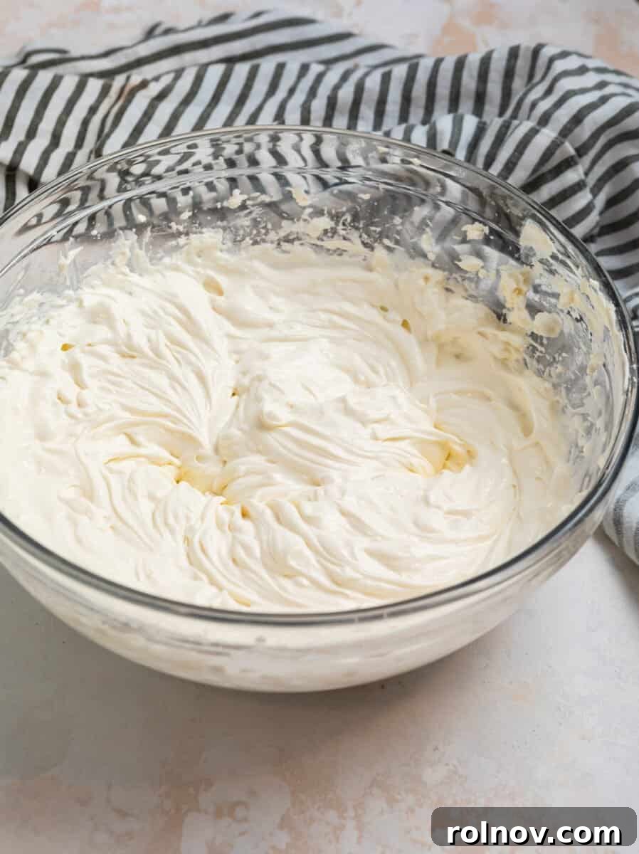 Cream cheese and cream mixed in glass mixing bowl.