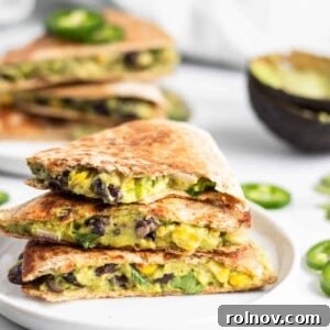 A perfectly cooked vegan quesadilla, golden brown with visible filling of black beans and avocado.