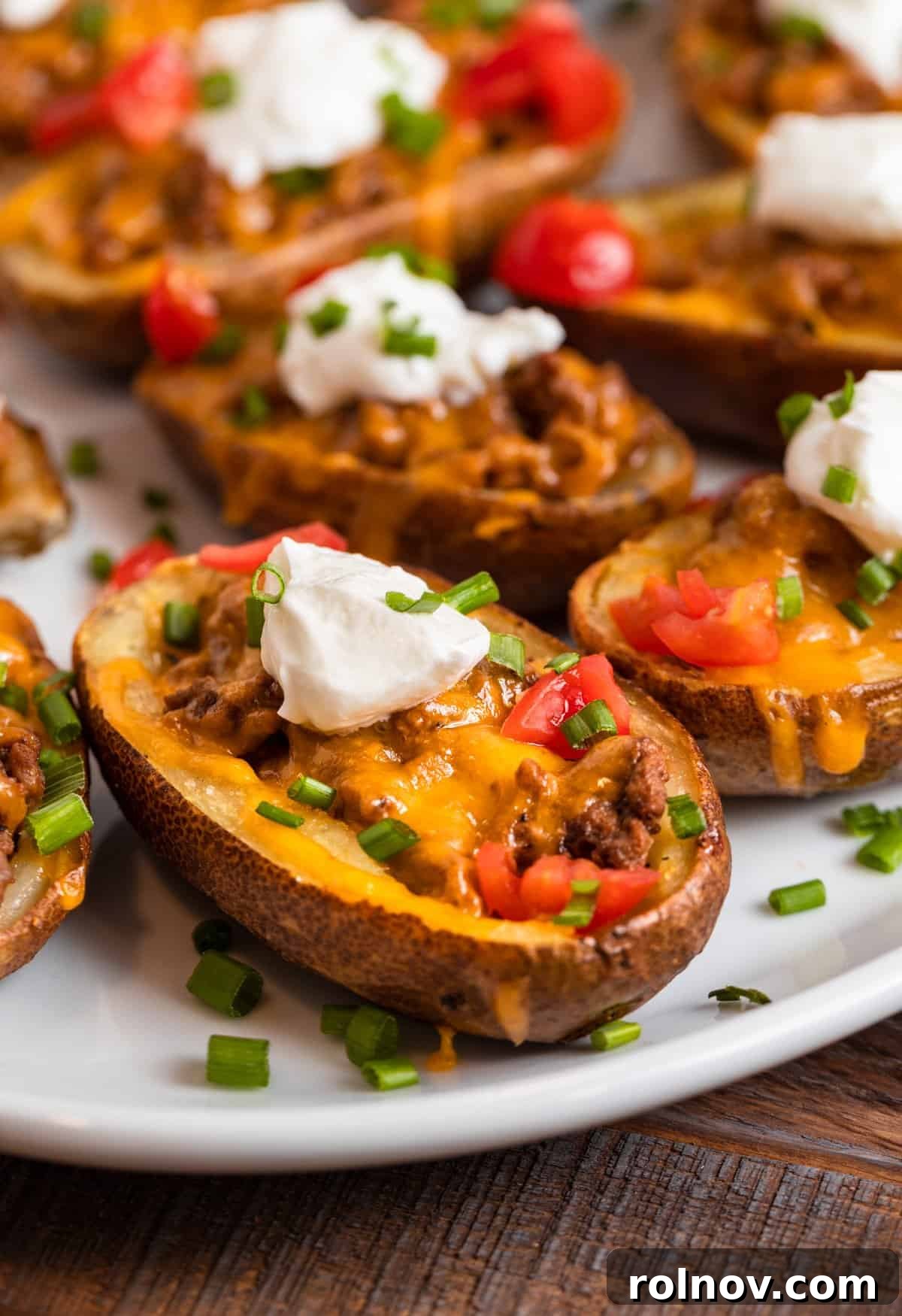 Cheesy Burger Potato Boats 3 Cheeseburger potato skins on white dish.