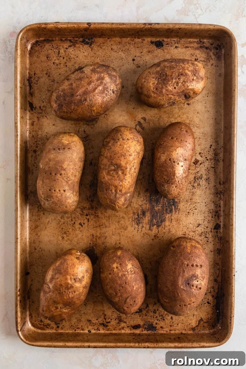 Cheesy Burger Potato Boats 4 Potatoes baked on a sheet pan.