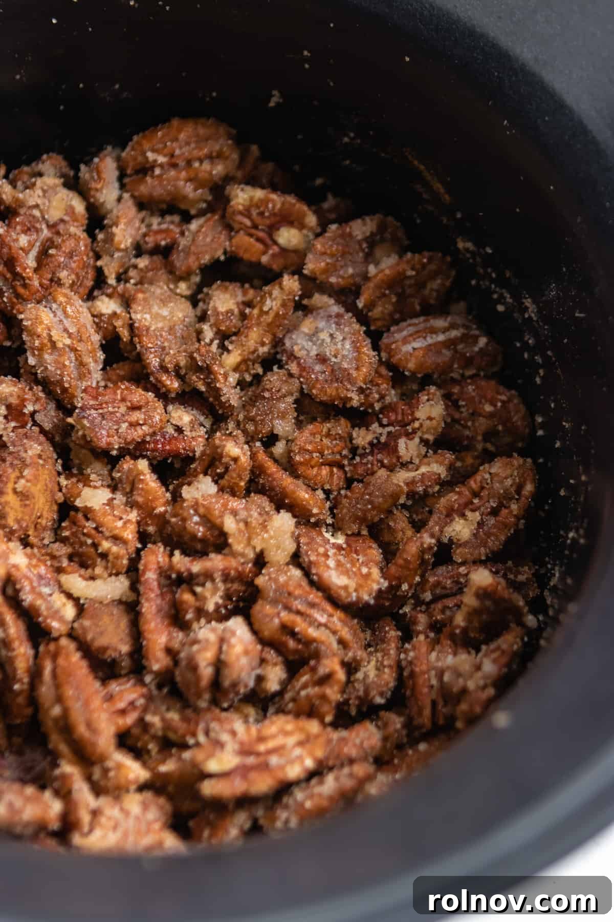 Crock Pot Pumpkin Spice Glazed Pecans 5 Slow cooker filled with raw pecans coated in a rich cinnamon sugar mixture, ready for cooking.