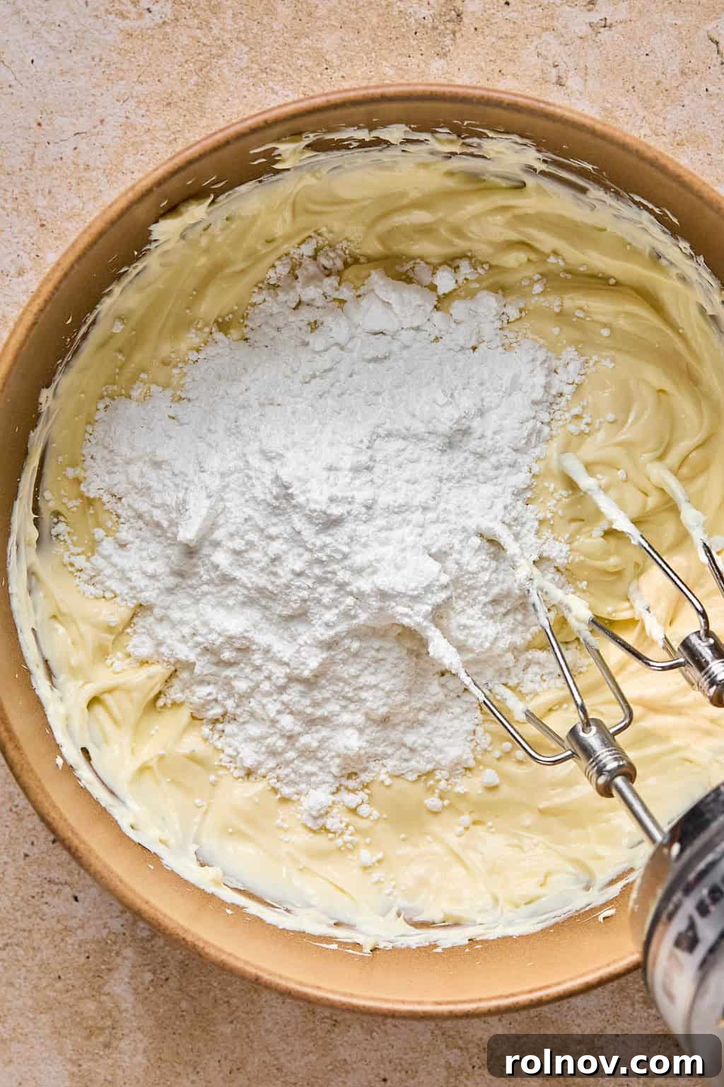 Golden Spiced Molasses Pumpkin Chews 13 Powdered sugar added to bowl with cream cheese frosting.